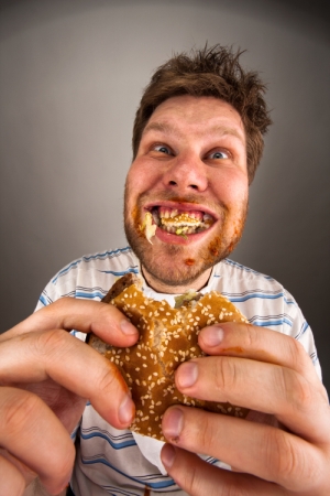 a man eating a burger in a messy way